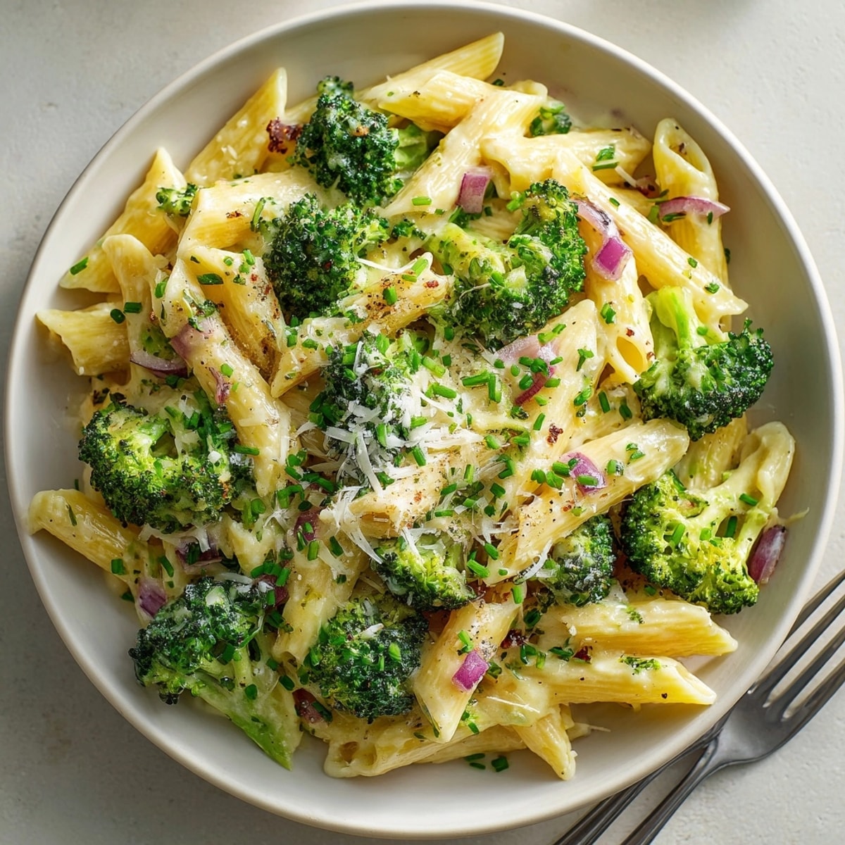 Festive Witch Night Broccoli Cheddar Pasta in a skillet, steam rising from cheesy, garlic-infused noodles.