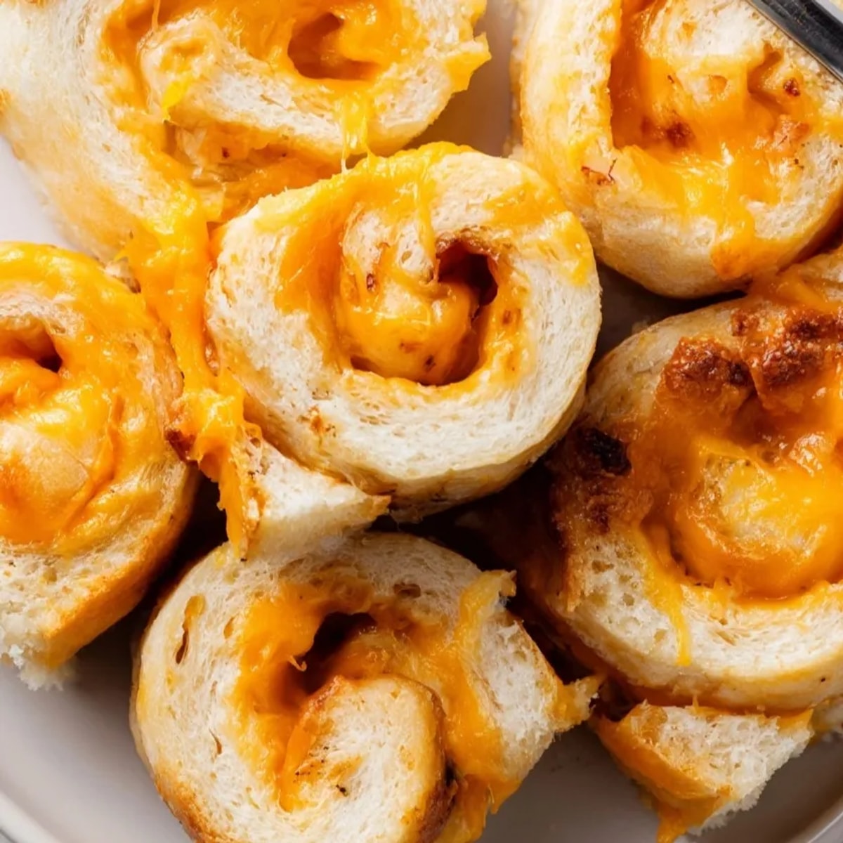 Golden brown TikTok Grilled Cheese Roll-Ups sizzle in butter till crispy, melty perfection.