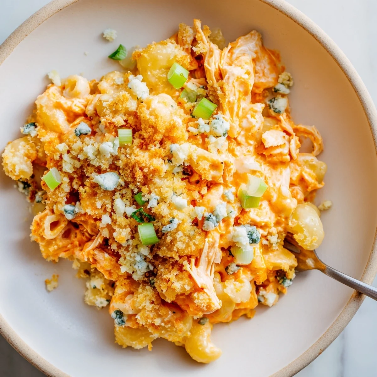 Creamy buffalo chicken dip mac and cheese topped with crunchy panko and scallions for flair.  