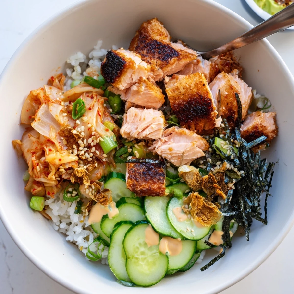 Flavorful crispy salmon rice bowl featuring garlic, tangy kimchi, and sesame seeds.  