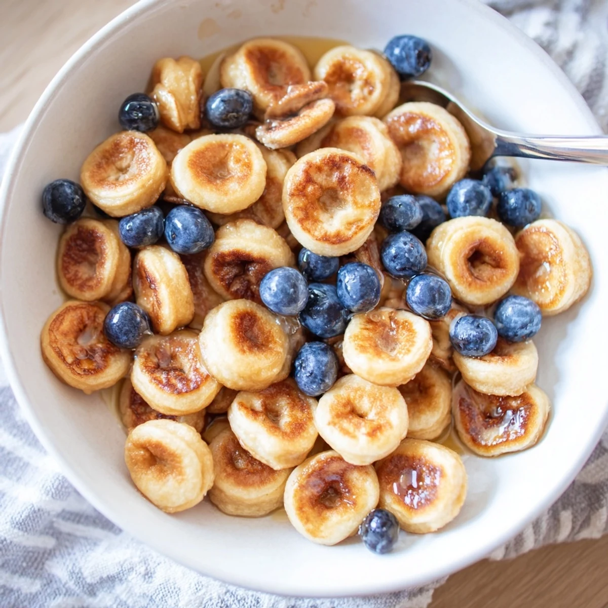 Delicious mini pancake cereal, perfect with syrup and fresh fruit for a fun brunch.