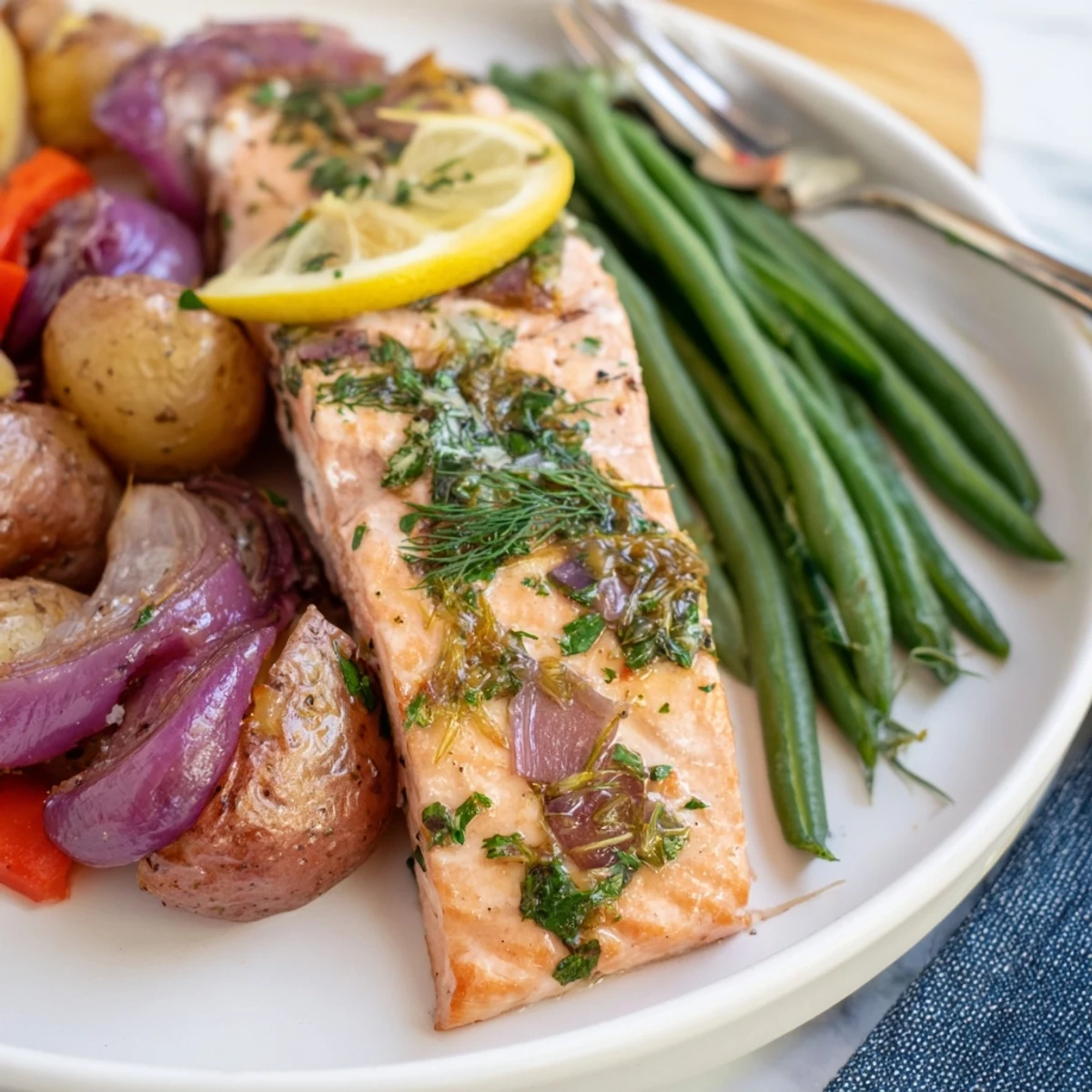 Lemon Herb Salmon & Potato Sheet Pan dish surrounded by colorful roasted veggies.
