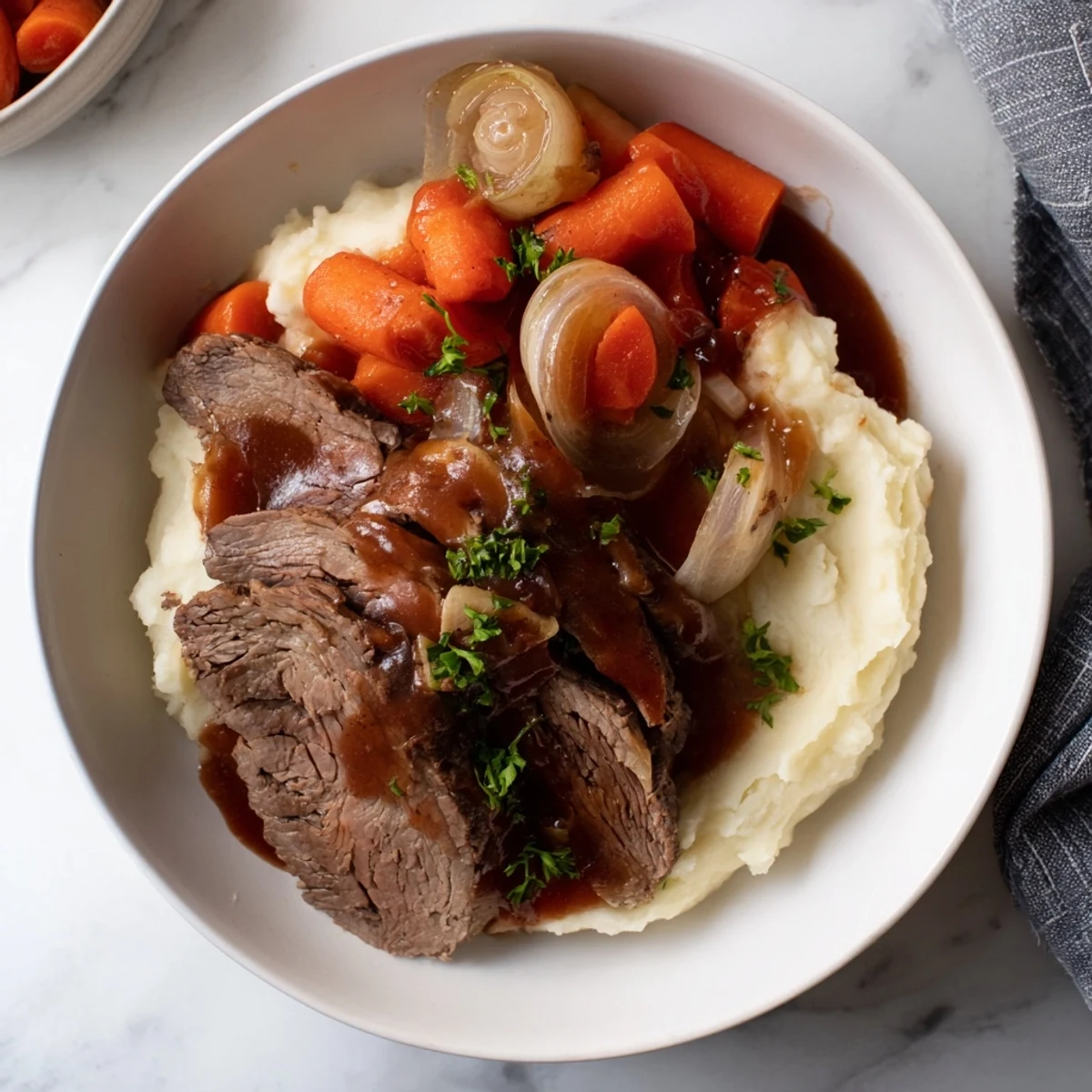 Savory slow cooker pot roast alongside smooth, fluffy mashed potatoes for the perfect meal.