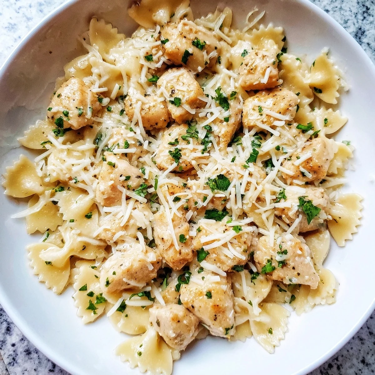 Steaming bowtie pasta with mozzarella garlic butter chicken offers creamy comfort in a bowl.