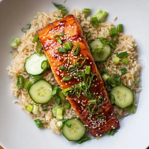 Sriracha Glazed Salmon, glistening with a spicy honey glaze, alongside fresh cucumber rice.