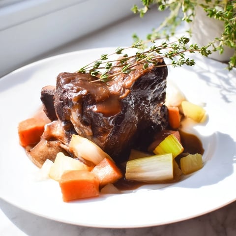 Juicy Apple Cider Braised Short Ribs served with a rich, glistening sauce, ideal comfort food.